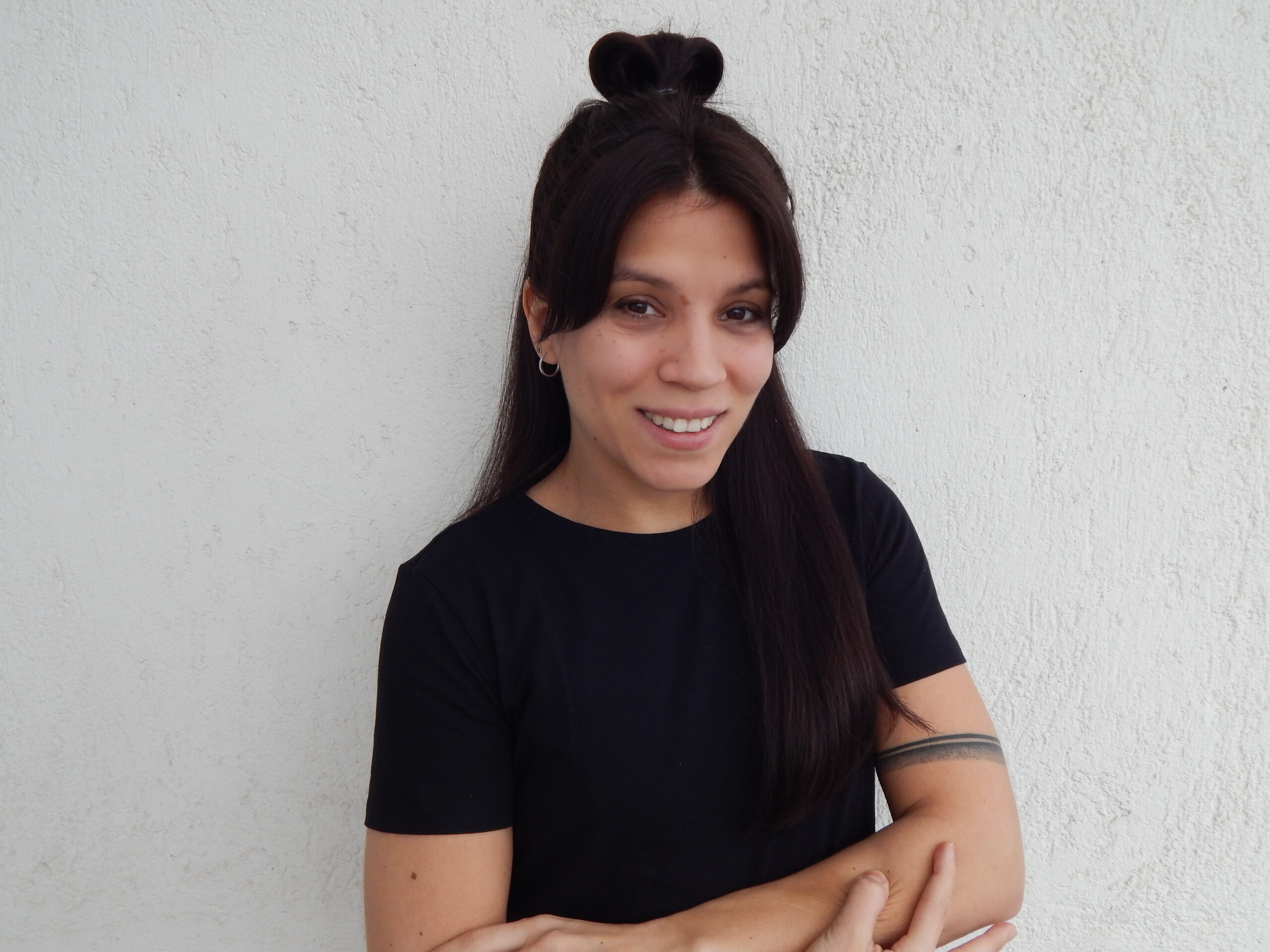 Szarka Boglárka, profi svédmasszőr, aki kiválóan beszél angolul, fekete pólót visel, és karbatett kézzel áll. Foglalj időpontot hozzá masszázsra a Pressure Point Masszázsszalonba!