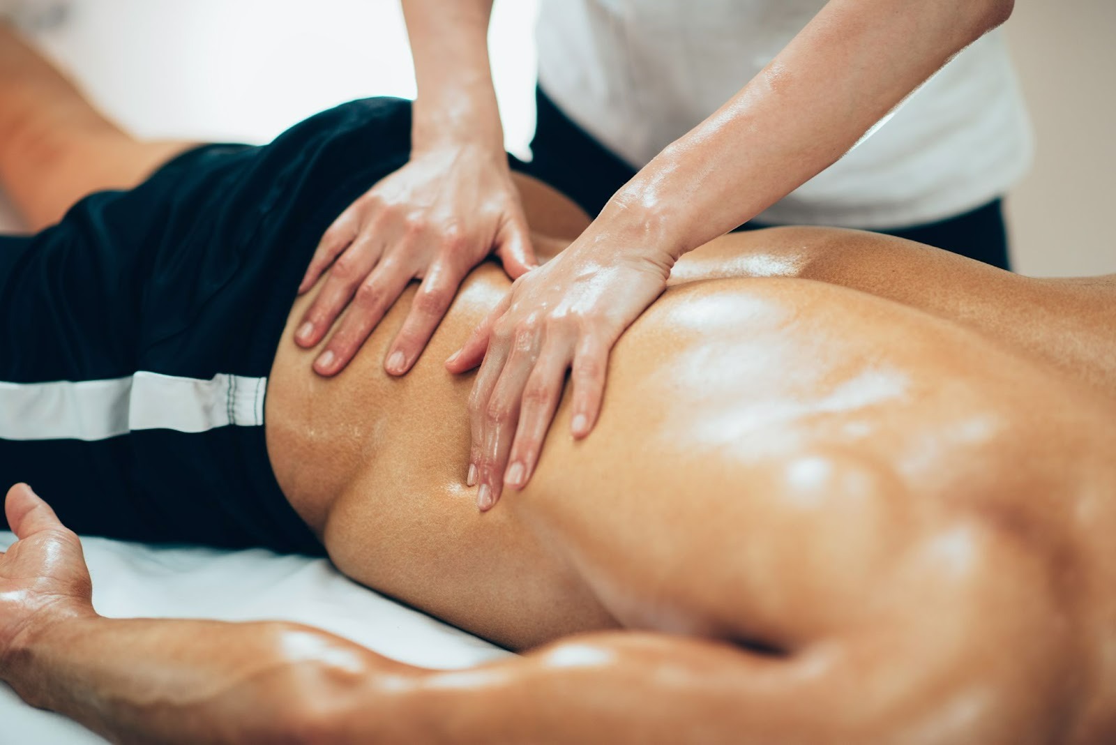 masseur massages an athlete's back in a massage parlor